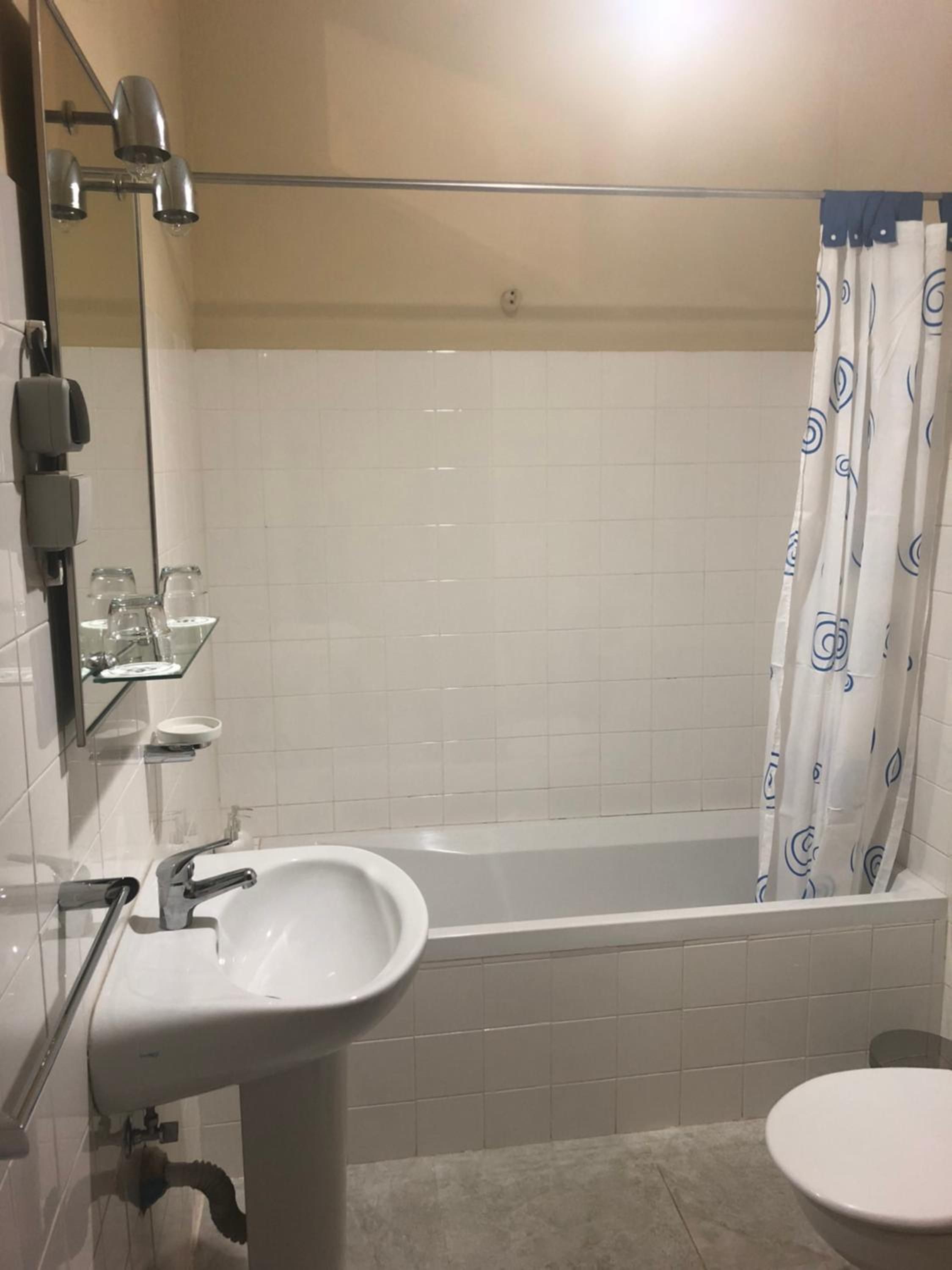 Un baño con bañera, lavamanos e inodoro.