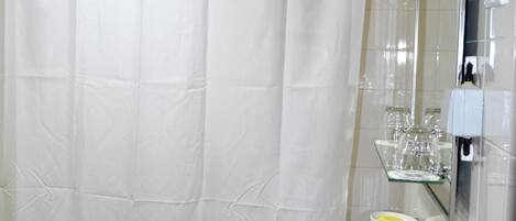 Un baño con una bañera, un lavabo blanco y un espejo.