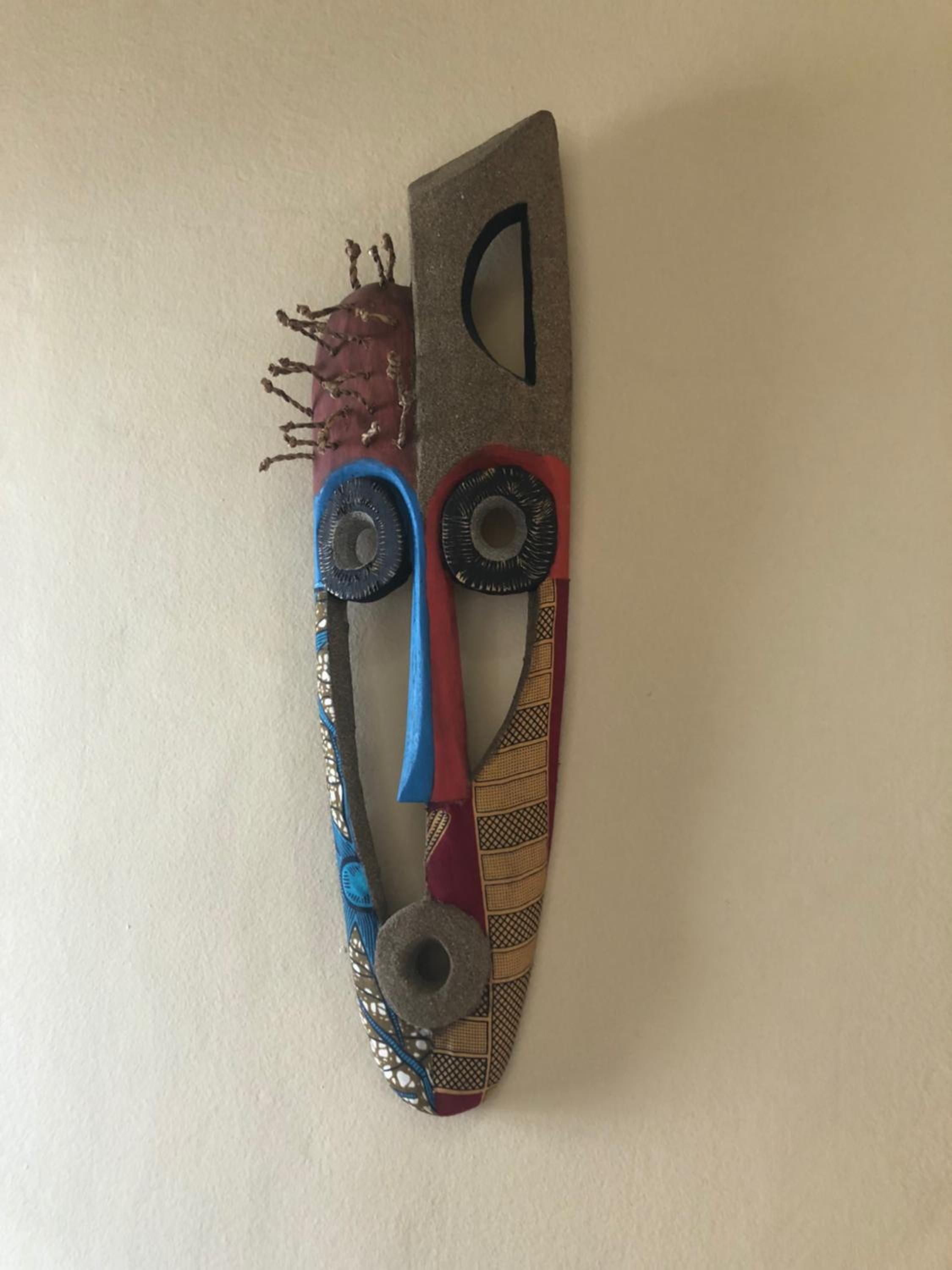 A wall-mounted abstract art piece with various textures and patterns.