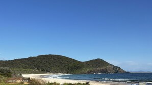 Une plage avec un panneau indiquant « Port de Byron Bay ».
