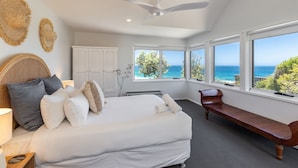A bedroom with a large bed, a wooden bench, and a view of the ocean. - Ningaloo - Boomerang Beach (Boomerang Beach)