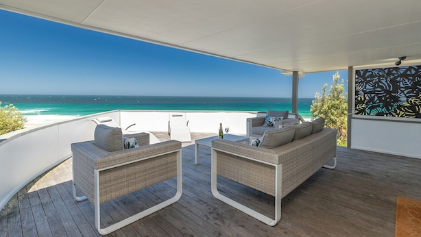 A covered outdoor seating area with wicker furniture and a view of the ocean. - Ningaloo - Boomerang Beach (Boomerang Beach)