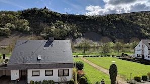 Un bâtiment blanc avec un toit gris, une petite fenêtre et une porte.