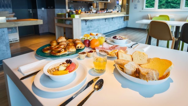 Um buffet de café da manhã com croissants, pão, frutas e sucos.