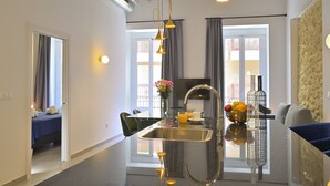 Een moderne keuken met een centraal kookeiland, een roestvrijstalen spoelbak en hanglampen.