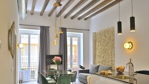 Een moderne woonkamer met een eethoek, een keuken met een spoelbak, en een balkon met uitzicht.