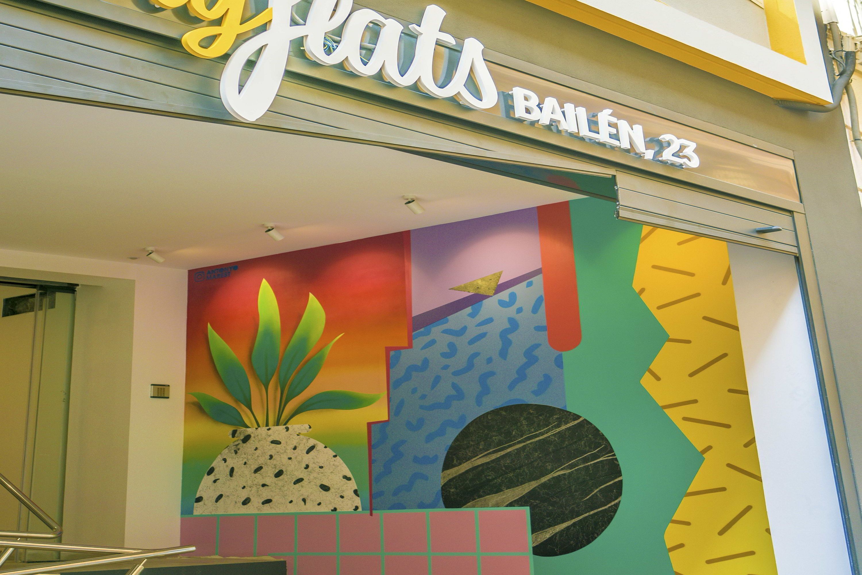 A colorful storefront with the name 'Ballen 23' and a vibrant mural with geometric shapes and a pineapple.