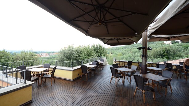 Een terras met zitplaatsen buiten en uitzicht op het landschap.