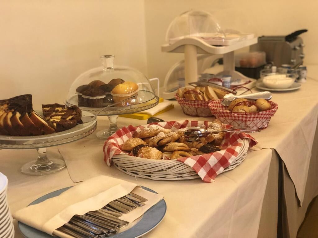 Une table de buffet proposant une variété de produits de boulangerie, notamment du pain, des viennoiseries et des muffins.