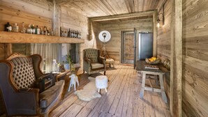 A rustic wooden interior with a sofa, armchair, and a small table with fruit. - Bauernhaus-Schloss Wagrain (Ebbs)