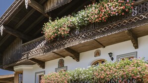 A traditional chalet with wooden balconies, white walls, and green shutters. - Bauernhaus-Schloss Wagrain (Ebbs)