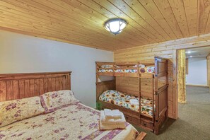 A bunk bed with floral bedding, a wooden headboard, and a single bed with a floral-patterned bedspread.