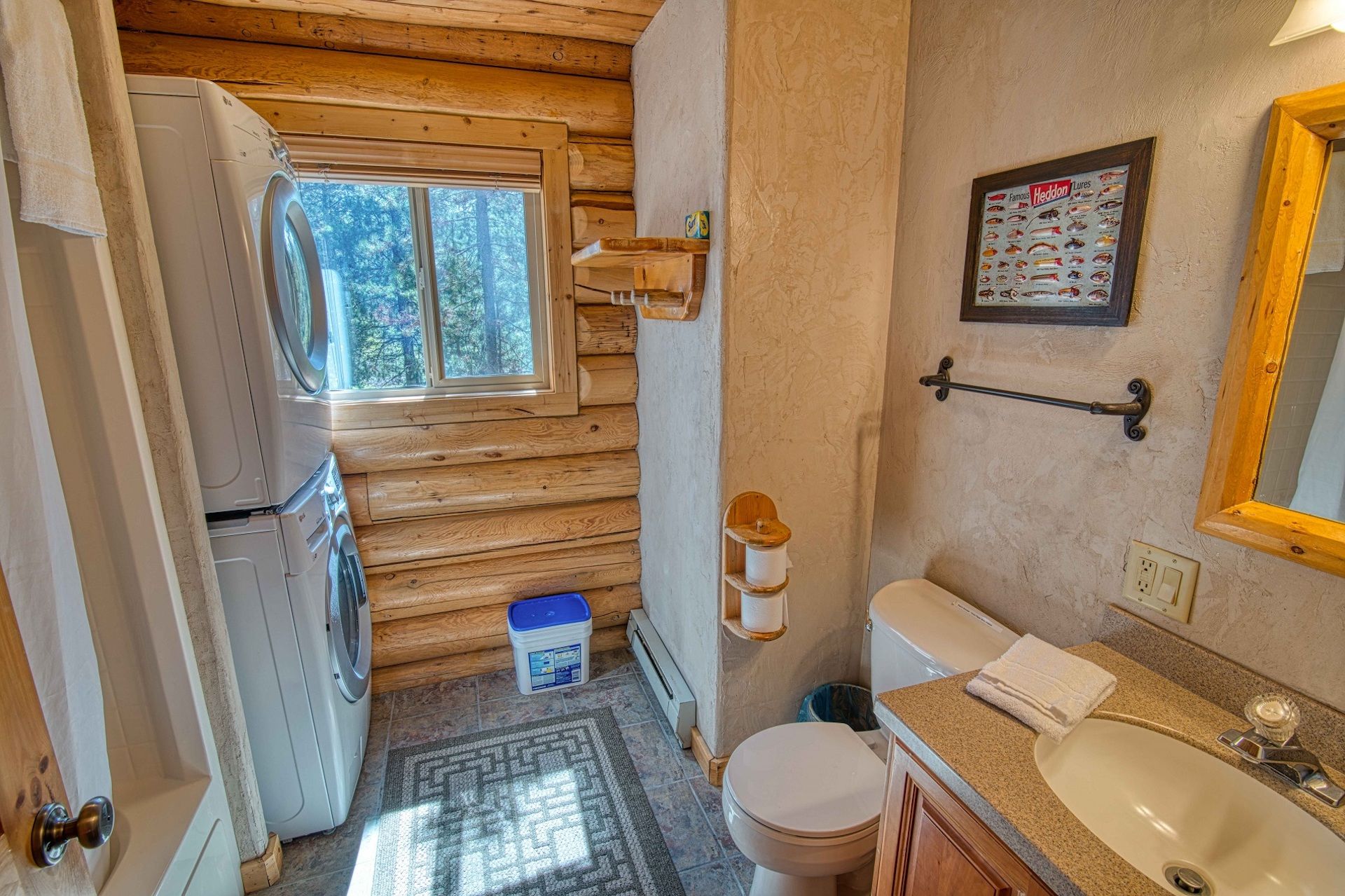 Ein kleines Badezimmer mit Toilette, Waschbecken und Holzwänden.