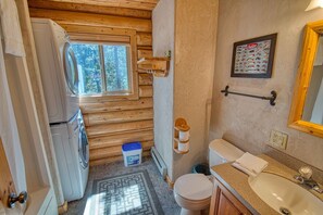 Une petite salle de bain avec des toilettes, un lavabo et des murs en bois.