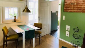 Un espace repas comprenant une table, des chaises, une fenêtre et une porte.