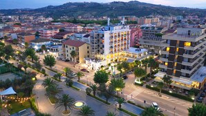 A hotel with multiple floors, a central courtyard, and a view of the surrounding cityscape. - Hotel Excelsior (Alba Adriatica)