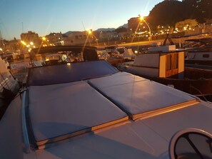 A rooftop with a flat surface, possibly a terrace or deck area, surrounded by buildings and street lights. - Desirè Charming House Boat (Palermo)