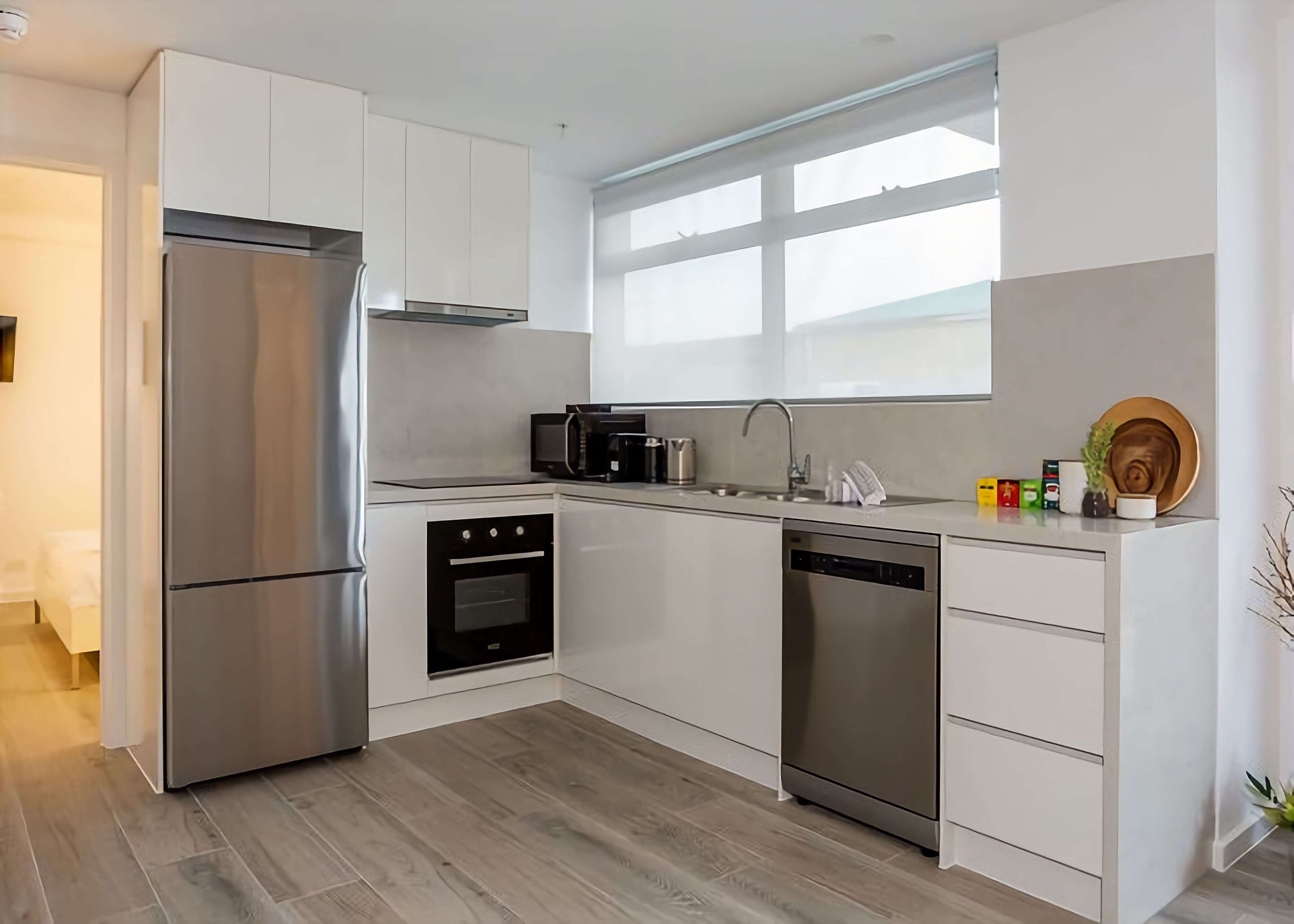 A modern kitchen with stainless steel appliances, a dishwasher, and a microwave.