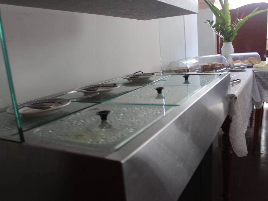 A glass display case with various items, a potted plant, and a table with food and drinks.