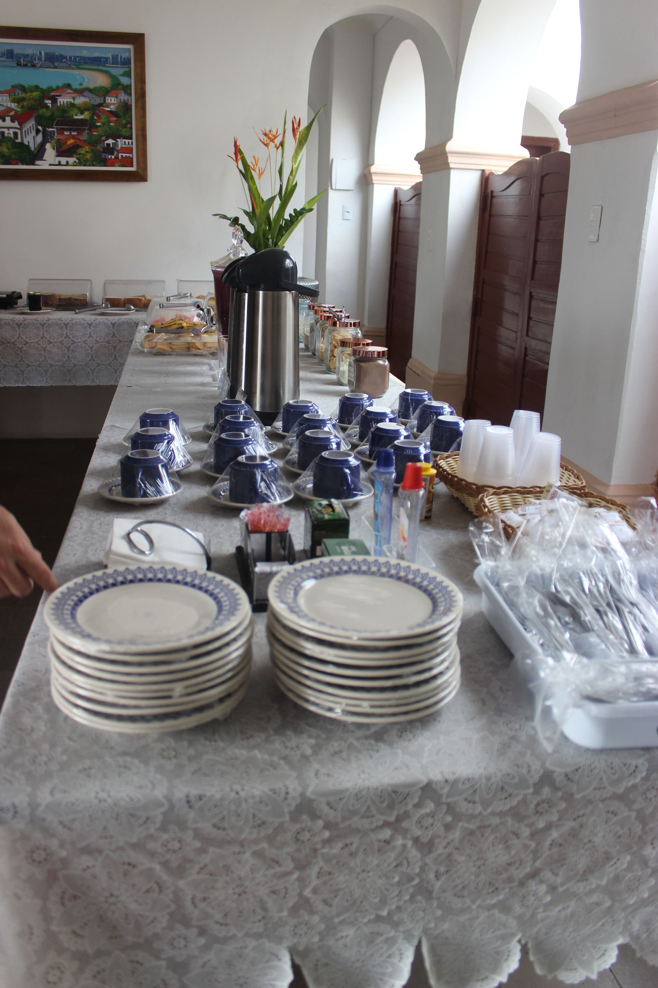 A table with stacked plates, bowls, and a potted plant.
