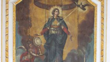 A detailed mural with a central figure, surrounded by ornate golden frames and a complex architectural background.