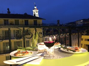 A balcony table with plates of food, a glass of red wine, and asparagus. - Quality apartment - balcony, elevator, cozy, well equipped,  view in Old Nice (Nice)