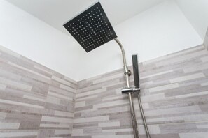 A shower with a square head and a handheld control.