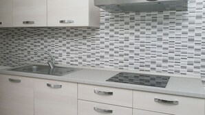 Een moderne keuken met een roestvrijstalen spoelbak, een magnetron en een inbouwoven.