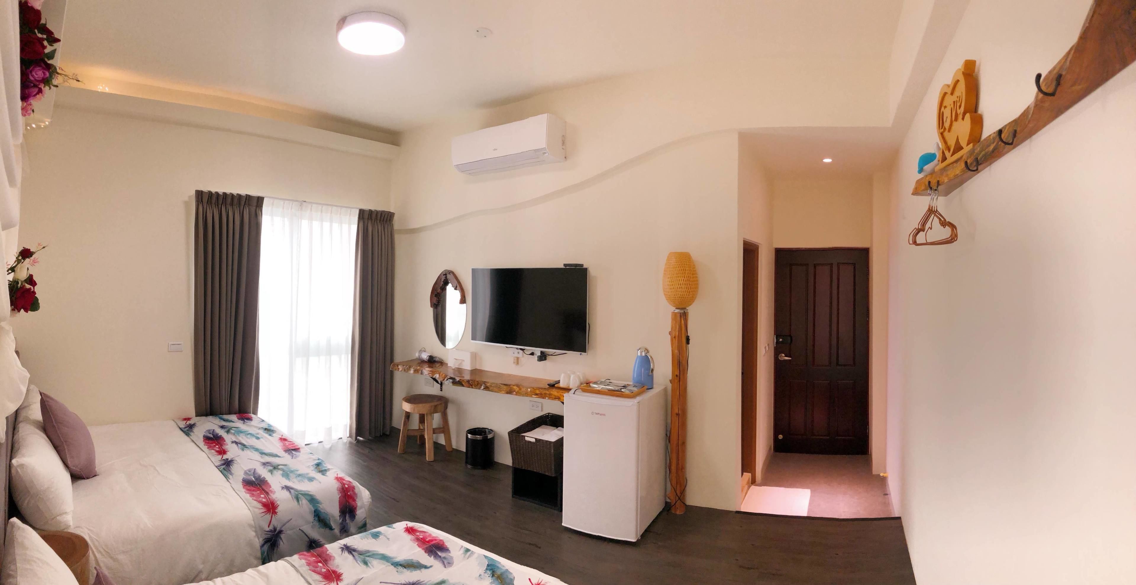 Una habitación de hotel con cama, escritorio, televisor y armario.