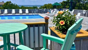 Enjoy the ocean view from our rooftop pool surrounded by comfortable lounge chairs and a small table.