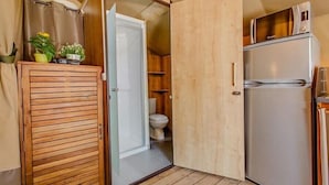 A compact kitchen with a refrigerator, a microwave, and a wooden cabinet. - Le Val de la Marquise - Tente Lodge (Campagne)