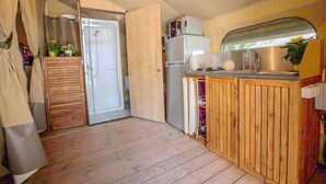 A compact kitchen with wooden cabinets, a refrigerator, and a sink. - Le Val de la Marquise - Tente Lodge (Campagne)