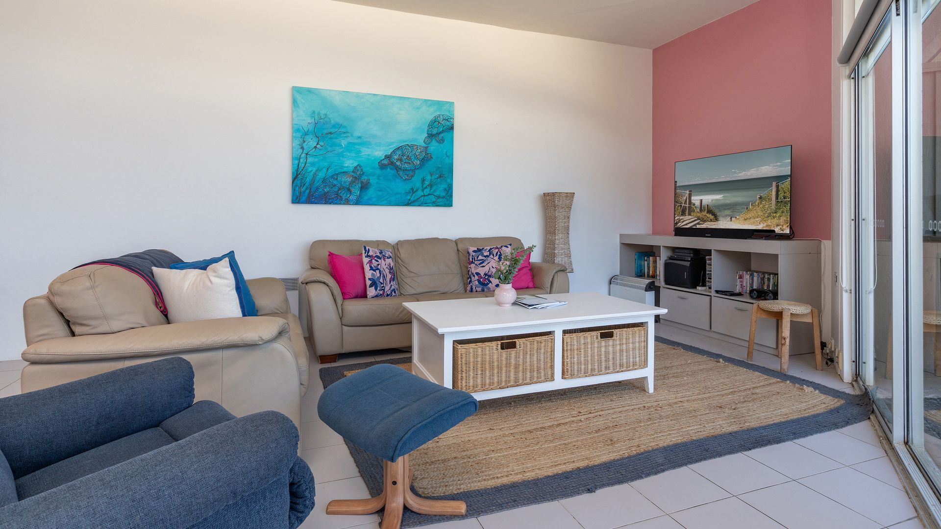 A living room with a sofa, a coffee table, and a television.