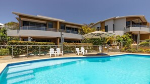 Un hôtel moderne doté d’une piscine, d’un espace extérieur aménagé et d’un jardin bien entretenu.