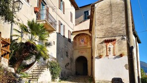 A cobblestone street leading to a building with a staircase and a small archway. - La Rocca - casa con terrazza vista mare in borgo medievale (Camaiore)