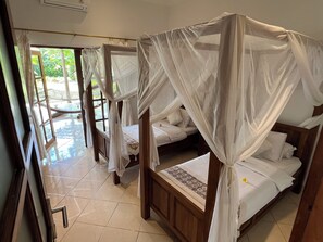 A room with four beds, each with a canopy, and a large window providing a view of the outdoors. - Beachvilla, 2/8 PRs. cooking incl. private pool, jacuzzi, massage, laundry  (Seririt)