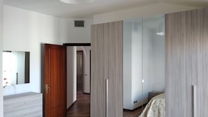 Ein Schlafzimmer mit Kleiderschrank, Nachttisch und Spiegel.