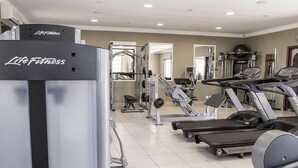 Ein Fitnessstudio mit Cardiogeräten, Gewichten und Spiegeln.