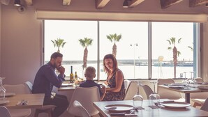Ein Restaurant mit Meerblick, ausgestattet für ein Familienessen.