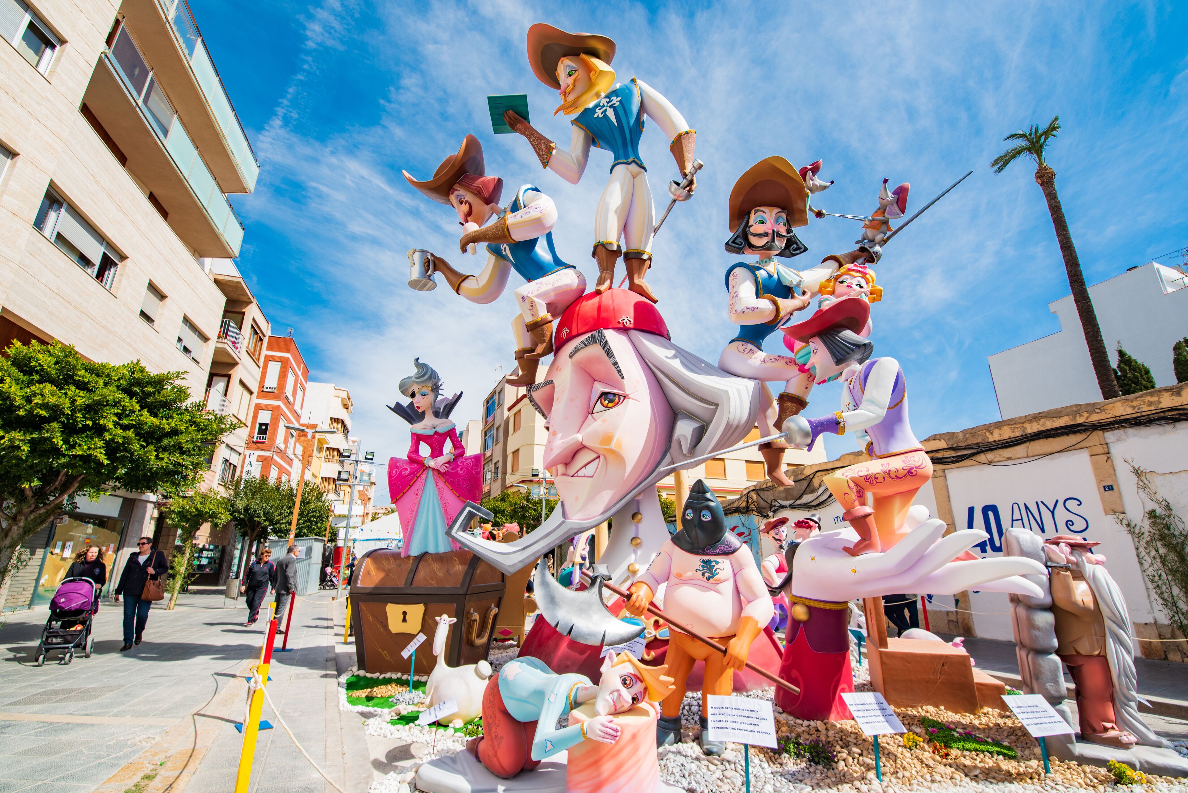 Een straatbeeld met een groot, kleurrijk beeld van verschillende figuren.