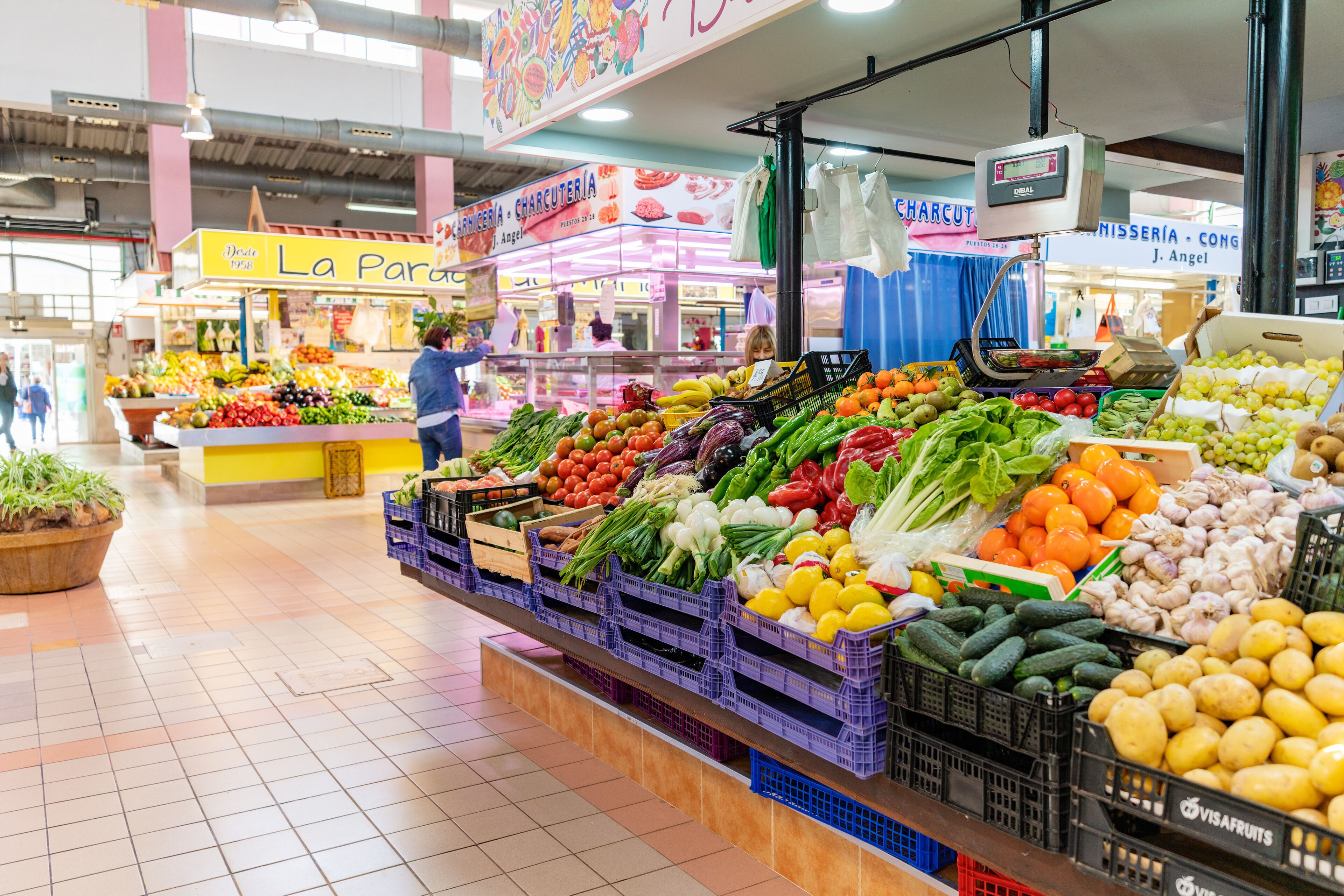 Une épicerie où les fruits et légumes frais sont présentés dans des bacs et des caisses.