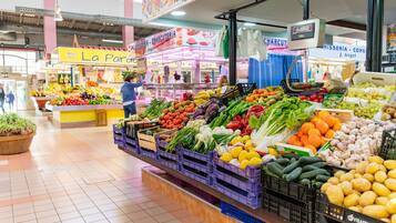 Een supermarkt met vers fruit en groenten, gepresenteerd in kratten en bakken.