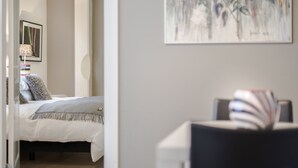 Een slaapkamer met een bed, een nachtkastje en een schilderij aan de muur.