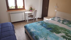 Habitación triple, 1 cama de matrimonio | Caja fuerte, escritorio, wifi gratis y ropa de cama