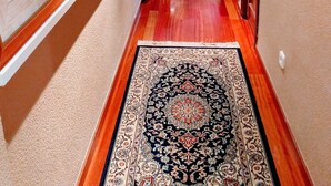A hallway with framed artwork on the walls, a patterned rug, and wooden flooring. - COLLECTION Bed & Breakfast, Centro Alicante I Cocina & Terraza - Jardín  (Alicante)