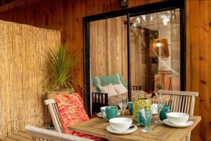 A wooden interior with a table set for dining, a chair, and a window with a view of the outside. - Yacu Beach (José Ignacio)