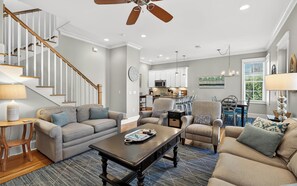 A spacious living room with a staircase, a dining area, and a kitchen. - Blue Cabana -Close To Red Fish and Beach, Pool, 3 Bikes (Santa Rosa Beach)
