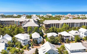 A coastal residential area with multiple-story buildings, some with balconies, and a clear view of the ocean. - Blue Cabana -Close To Red Fish and Beach, Pool, 3 Bikes (Santa Rosa Beach)