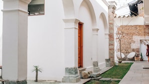 Un edificio blanco con arcos y una pared de ladrillo.