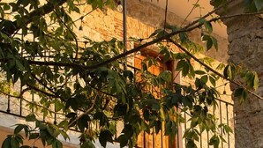 A building with a wooden door, stone walls, and a balcony with metal railings. - Hotel Tabáa Oaxaca (Oaxaca)